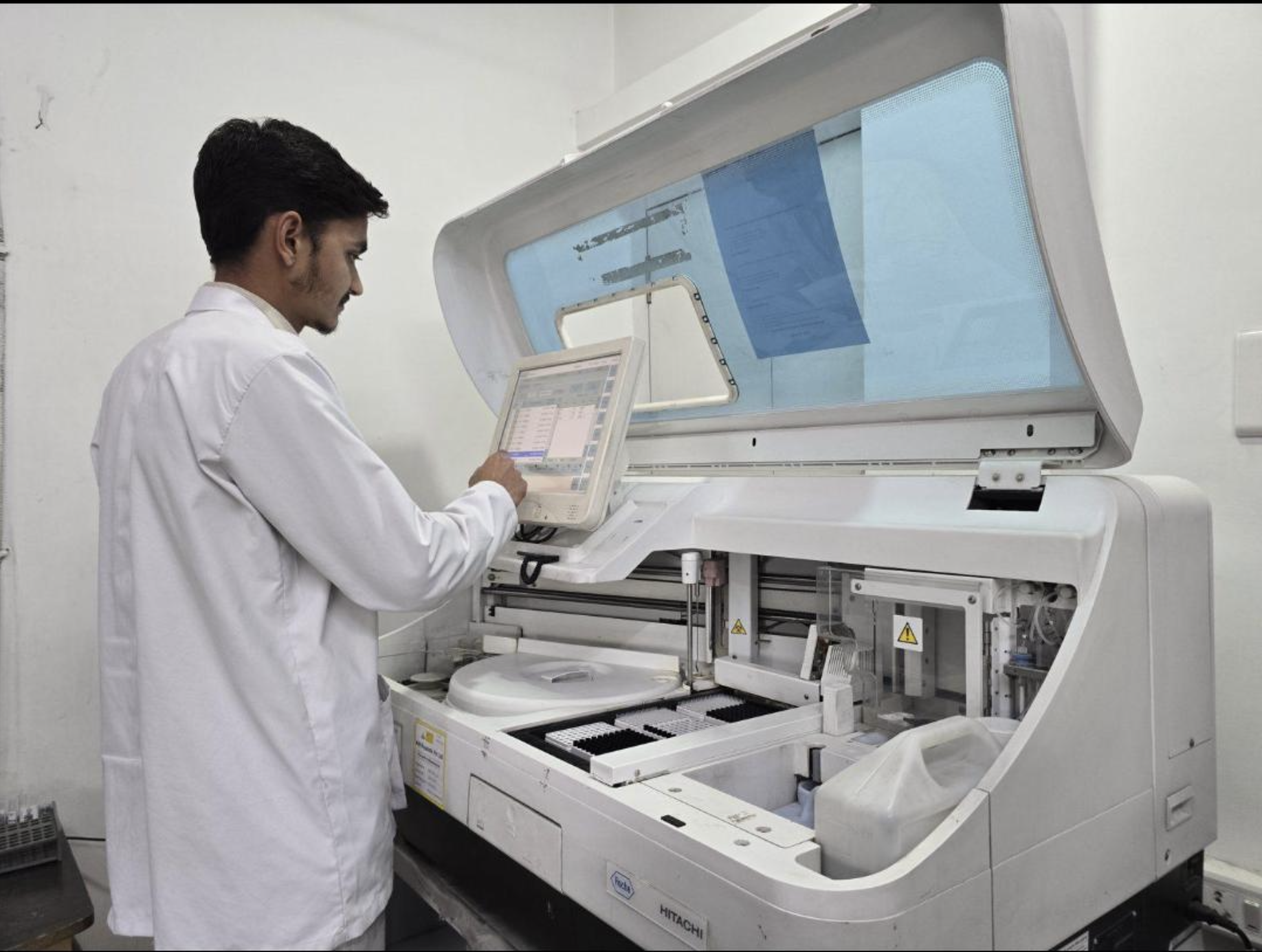 Medical technologist operating an automated clinical chemistry analyzer at EuroMed Diagnostics